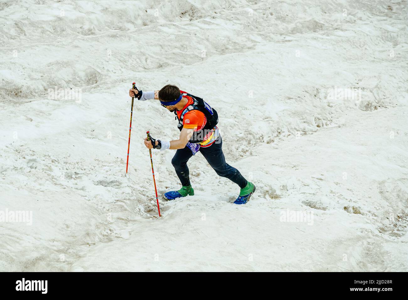 Arkhyz, Russia - July 2, 2022: male athlete walking snowy uphill in Arkhyz X Run Stock Photo