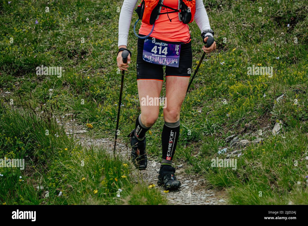 Arkhyz, Russia - July 2, 2022: female athlete walking mountain trail in Arkhyz X Run Stock Photo