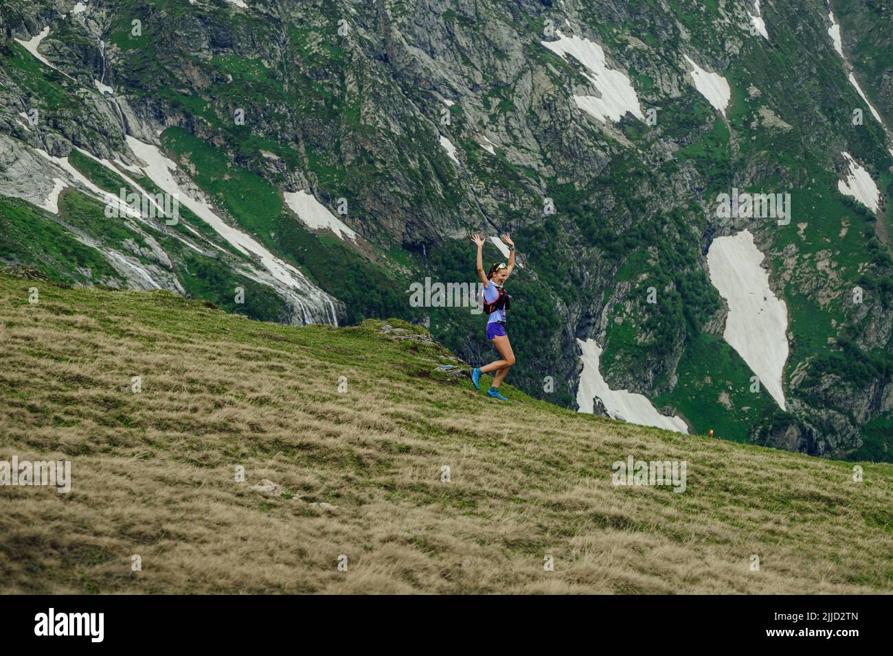 Arkhyz, Russia - July 2, 2022: female runner run trail down mountain in Arkhyz X Run Stock Photo
