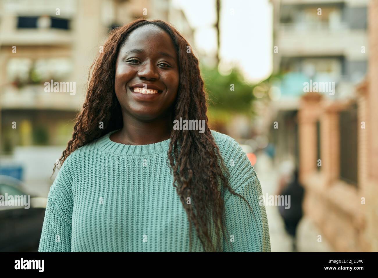 Young african woman smiling happy at the city Stock Photo - Alamy