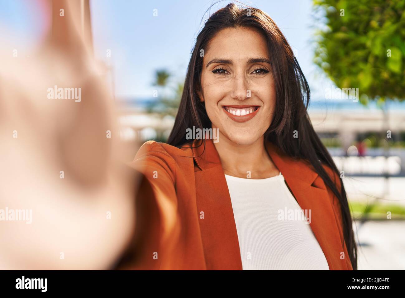 Young hispanic woman smiling confident making selfie by the camera at ...
