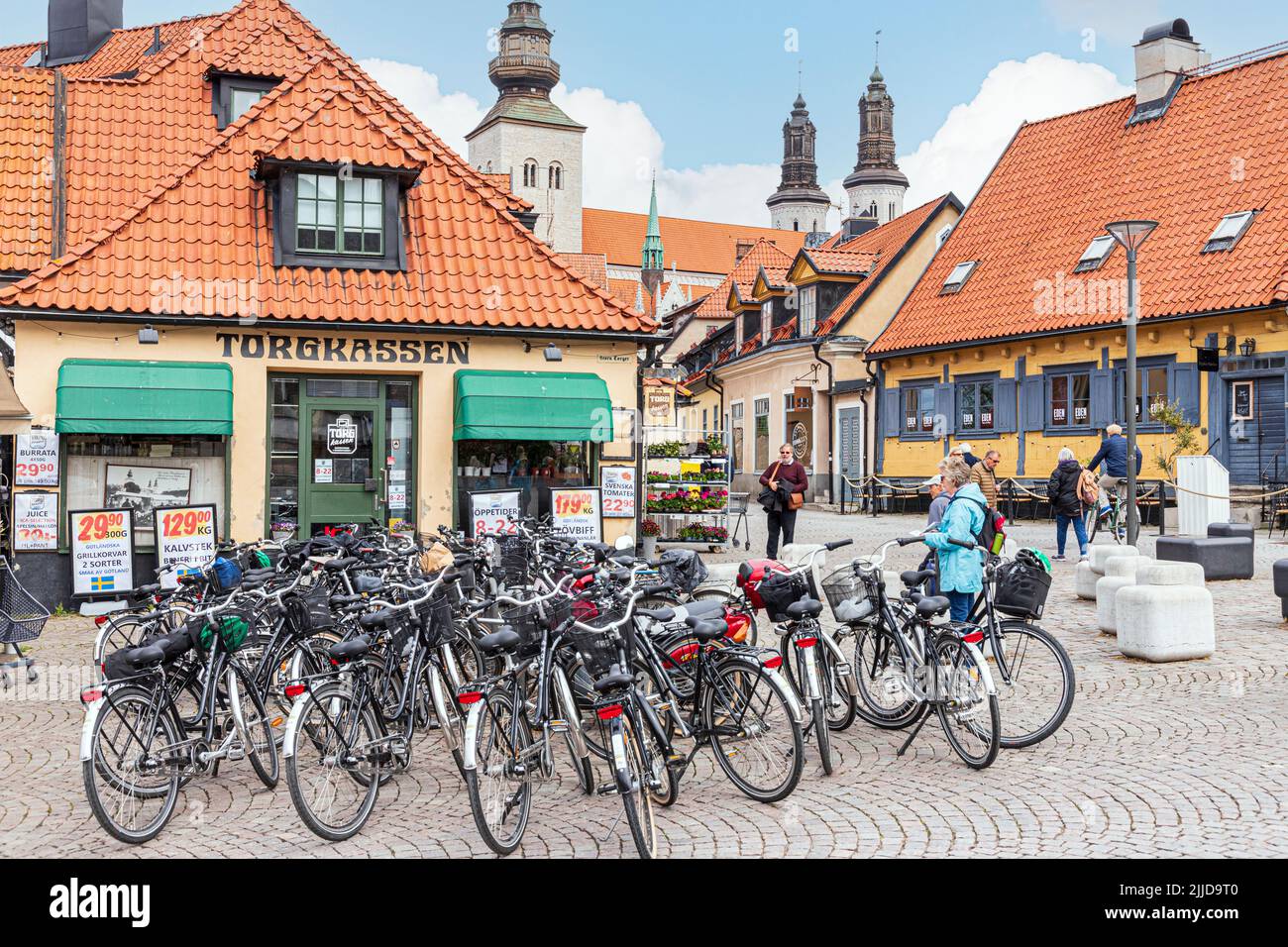 Shops and bicycles in the Great Square (Stora Torget) in the medieval town of Visby on the island of Gotland in the Baltic Sea off Sweden Stock Photo