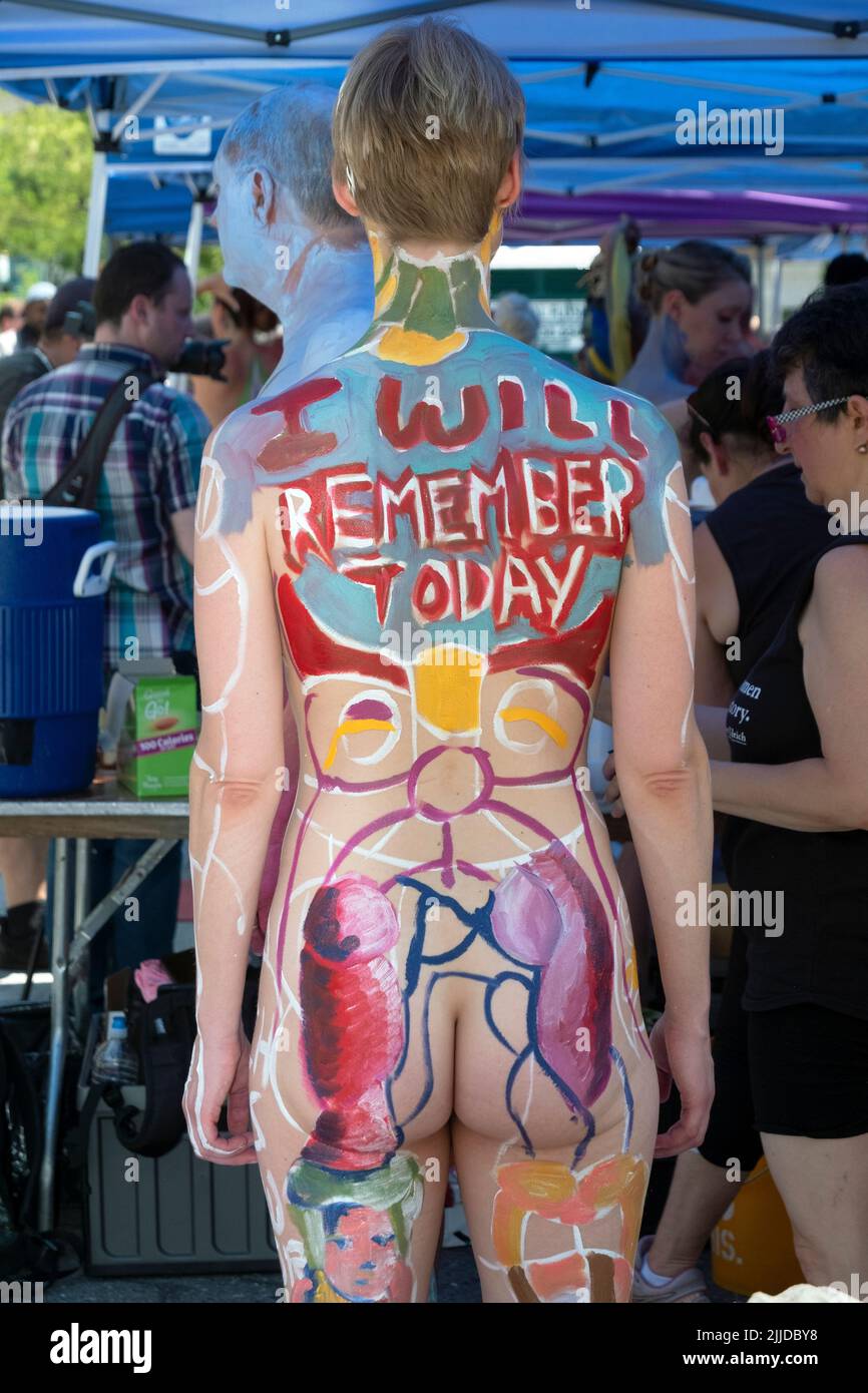 A rear view of an unidentifiable slender young lady at NYC Body Painting Day in Union Square Park in Lower Manhattan, New York. Stock Photo