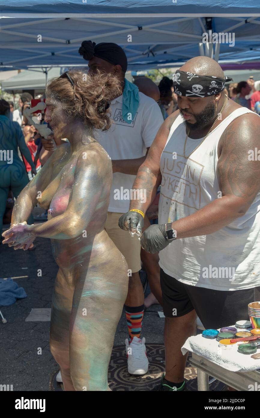 A woman gets painted in a metallic finish at NYC Body Painting Day  in Union Square Park in Manhattan, NYC Stock Photo