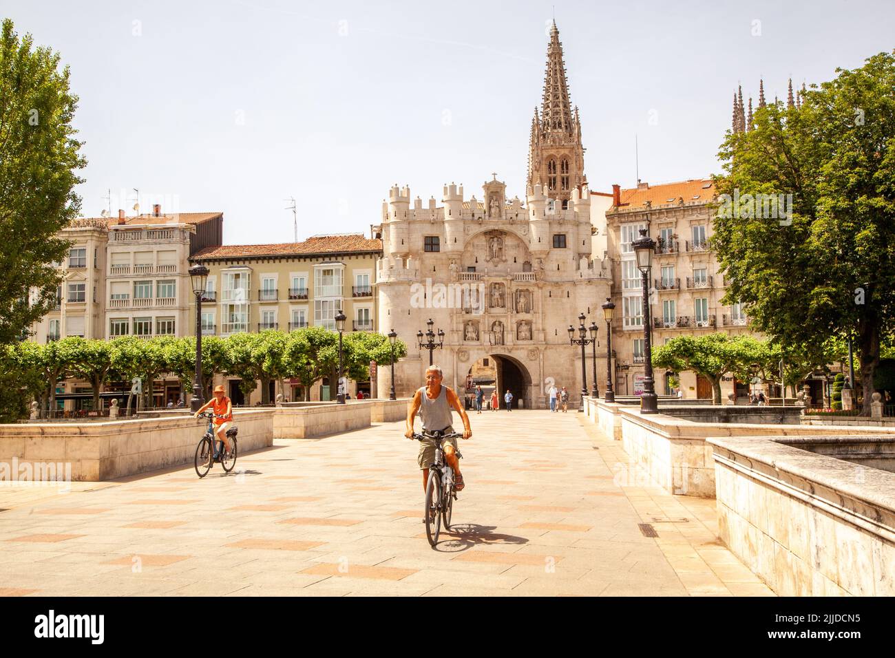 Man  and woman cycling over the bridge of Santa María outside the city gate of Santa Maria, in the Spanish city of Burgos Spain  Spain Stock Photo