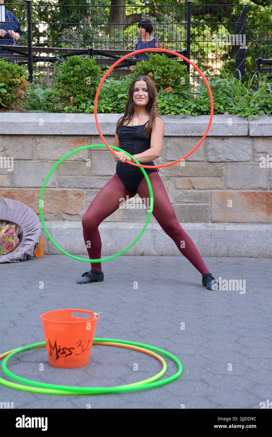 Miss 360, a street performance artist who works with hula hoops, performing at Union Square Park in New York City Stock Photo