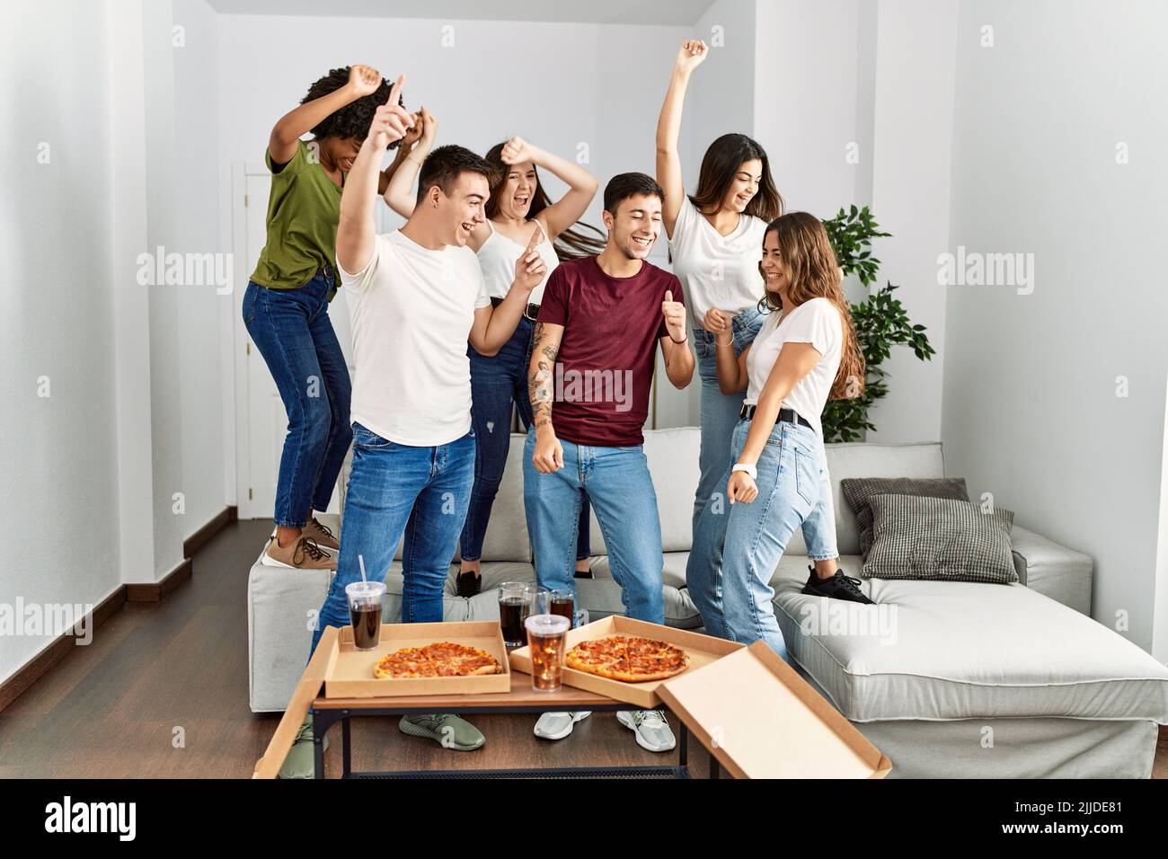 Group of young friends having party eating italian pizza and and