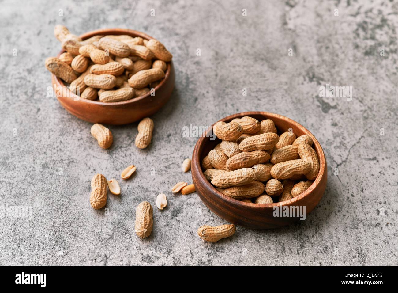 Image of bunch of peanuts in a bowl on a concrete surface Stock Photo