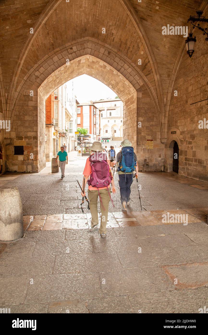 Pilgrims walking the Camino de Santiago, the way of St James entering the city gate of Santa Maria, in the Spanish city of Burgos Spain Stock Photo