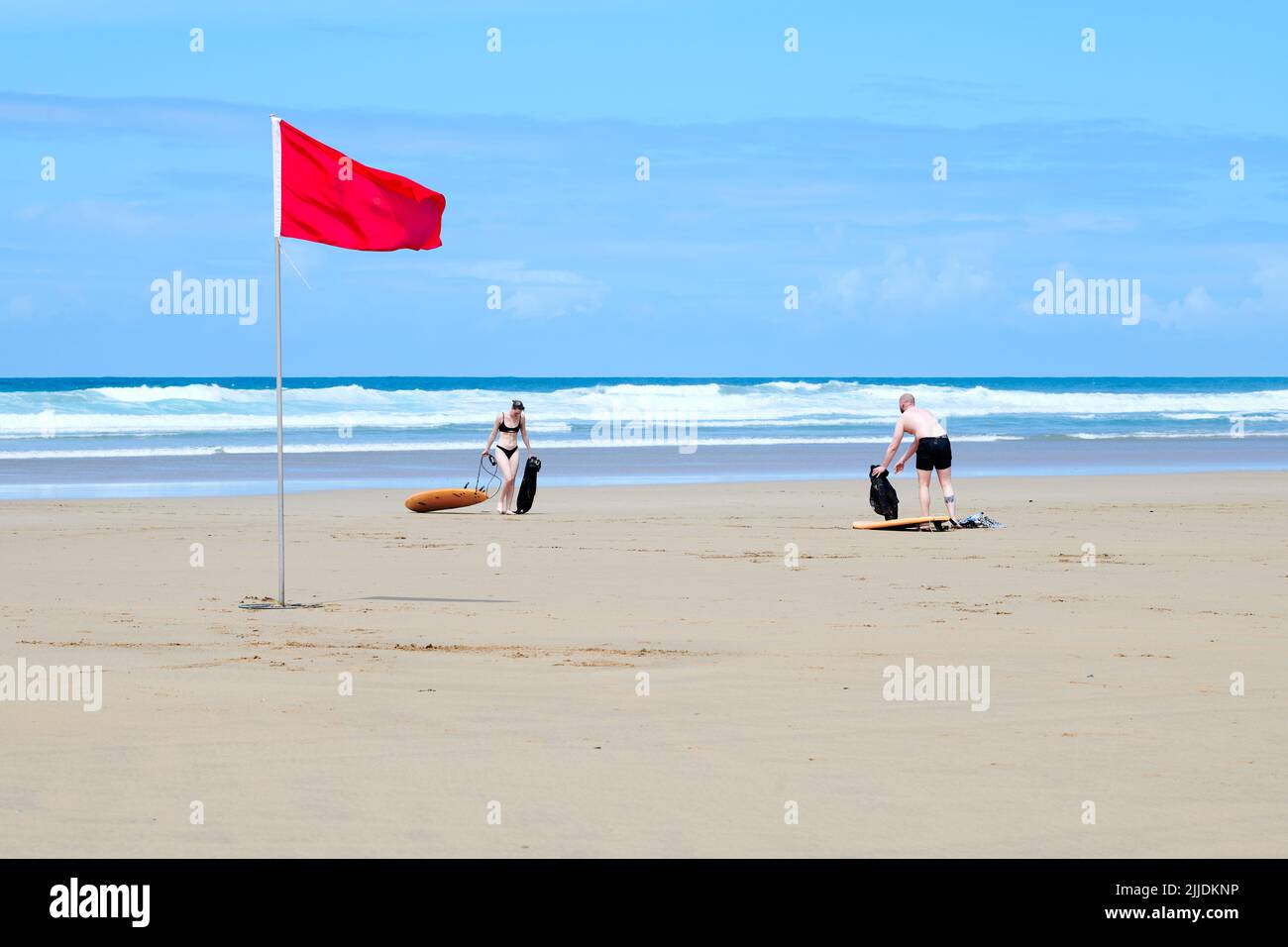 Red flag on the shore as surfing is cancelled due to treacherous wave conditions at Mawgan Porth beach, Cornwall, England. Stock Photo