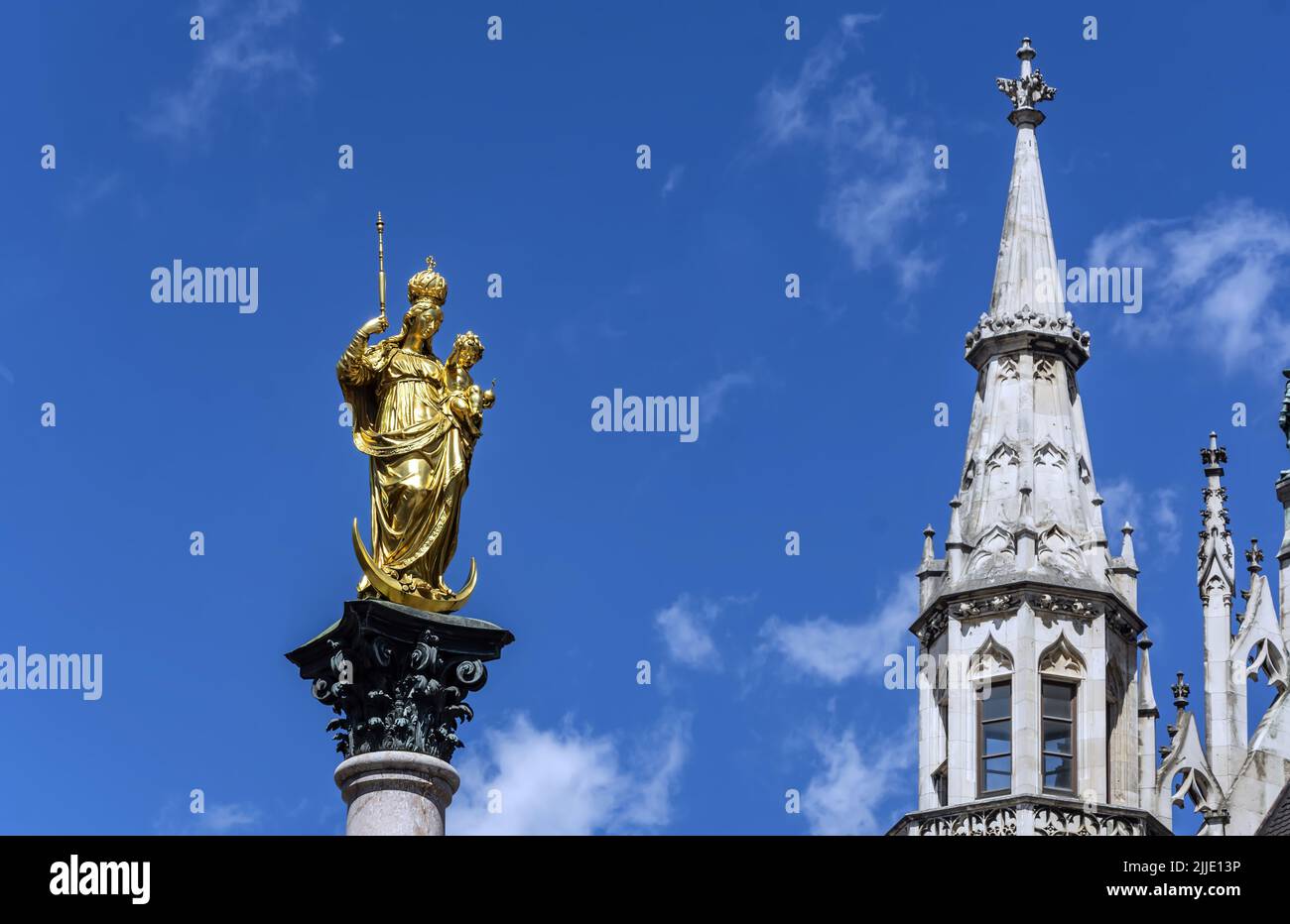 The statue of the Mariensäule on Marienplatz in Munich. The Mariensäule is a golden colored statue depicting the Madonna and Child Jesus standing on a Stock Photo