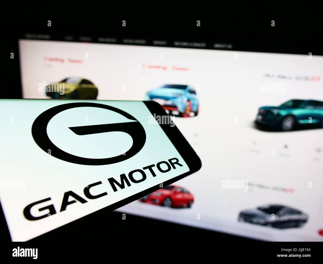 Smartphone with logo of Guangzhou Automobile Group Co., Ltd. (GAC) on screen in front of company website. Focus on center-right of phone display. Stock Photo