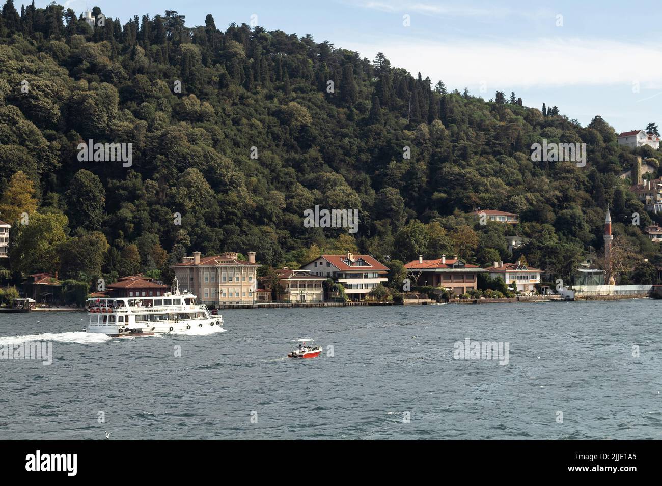 View of cruise tour boat on Bosphorus and historical and traditional mansions in Kandilli area of Asian side of Istanbul. It is a sunny summer day. Be Stock Photo