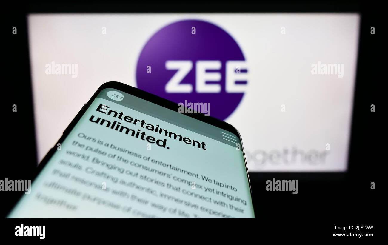 Mobile phone with website of company Zee Entertainment Enterprises Limited on screen in front of logo. Focus on top-left of phone display. Stock Photo