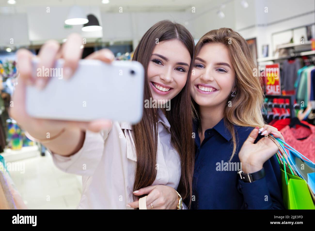 Best friends taking selfies while out on a shopping spree. Stock Photo