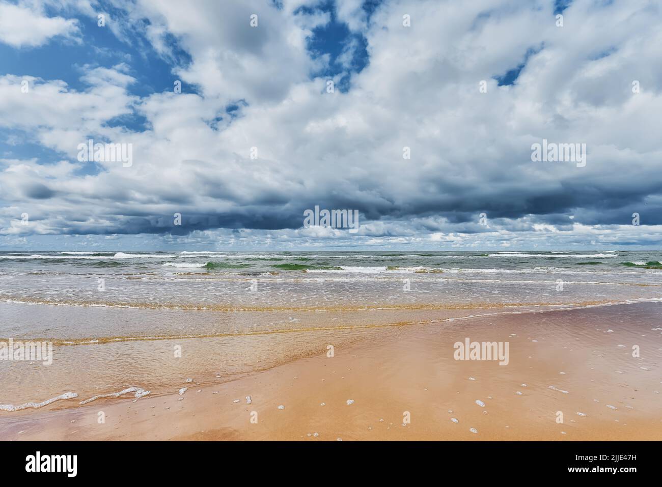 Beautiful summer sea landscape with a dramatic cloudy sky, and windy weather on the Baltic seashore. Latvia, Ventspils. Stock Photo