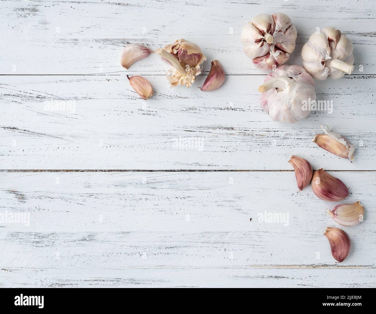 Garlic bulb and cloves over wooden table with copy space Stock Photo ...