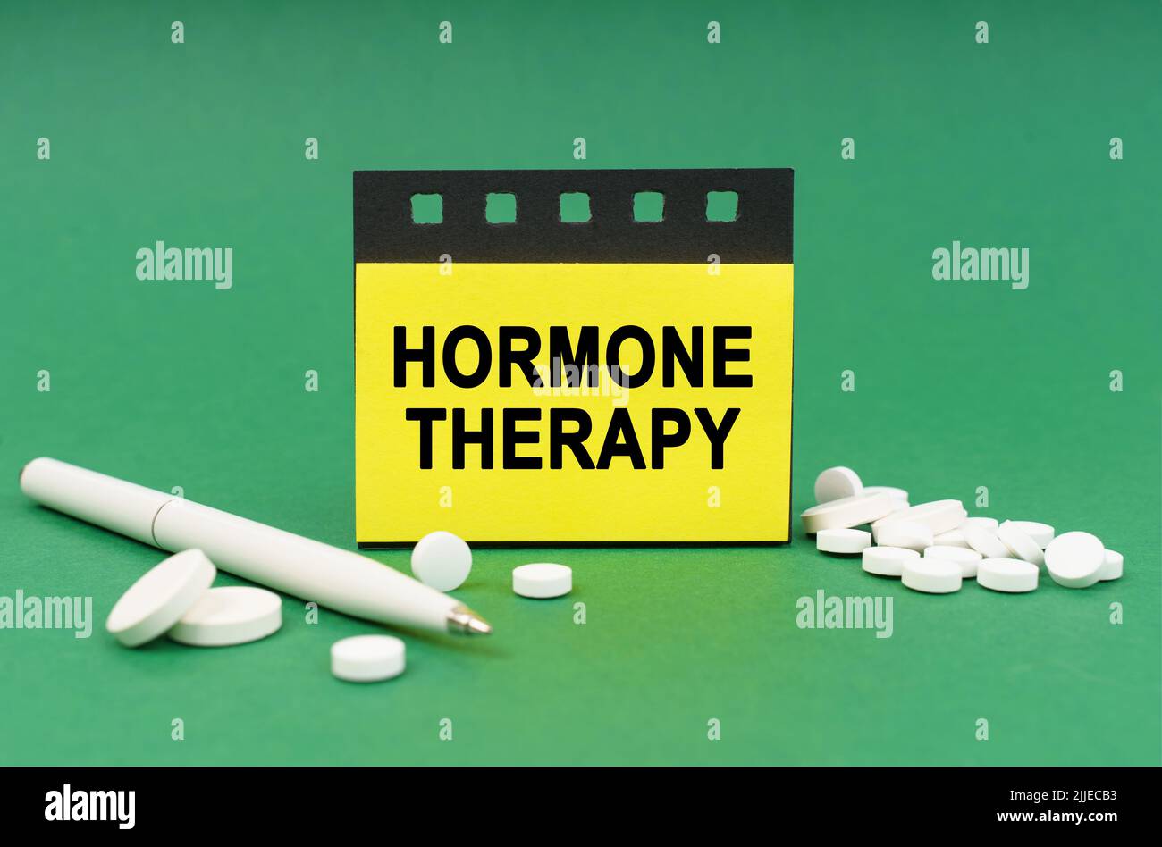 Medical concept. On the green surface are tablets, a pen and stickers with the inscription