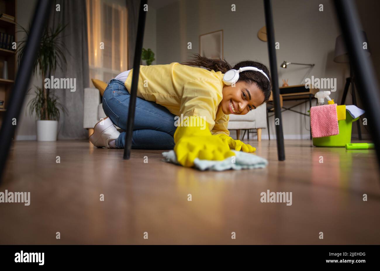 Black Lady Dusting And Mopping Floor With Rag At Home Stock Photo