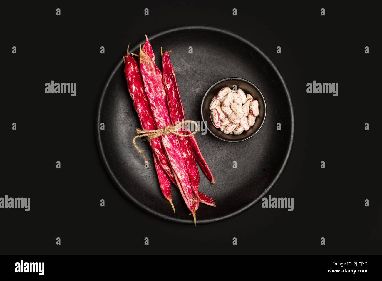 Pinto beans in a black bowl and on a black plate on black background  in a top view Stock Photo