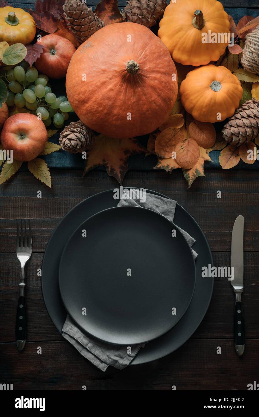 Autumn table place setting with drying leaves and pumpkins. Happy Thanksgiving Day. Vertical. Top view. Stock Photo