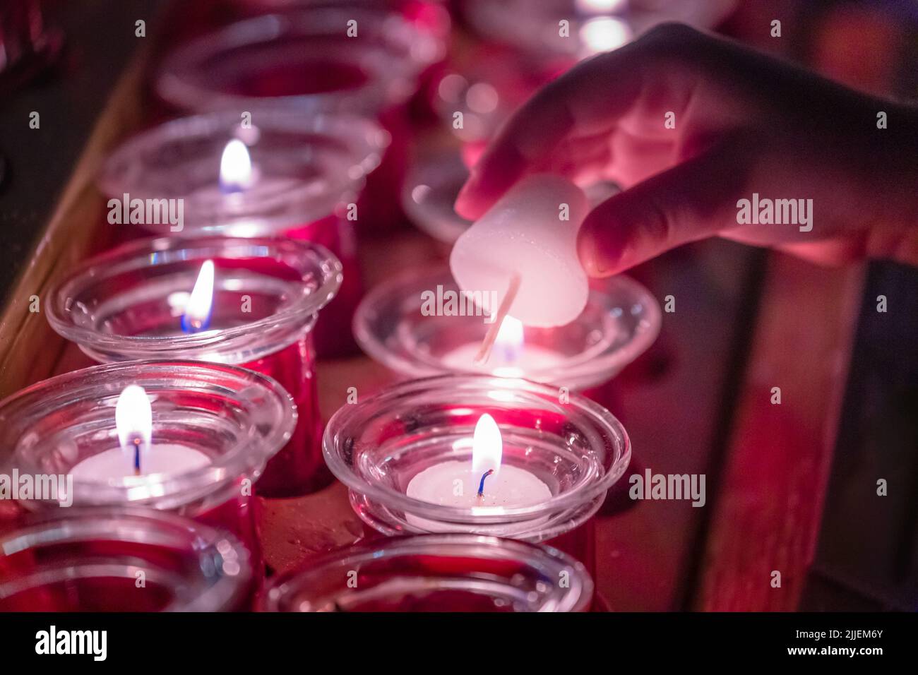 Hand Lighting up some prayer candles inside a church in Vienna, Austria