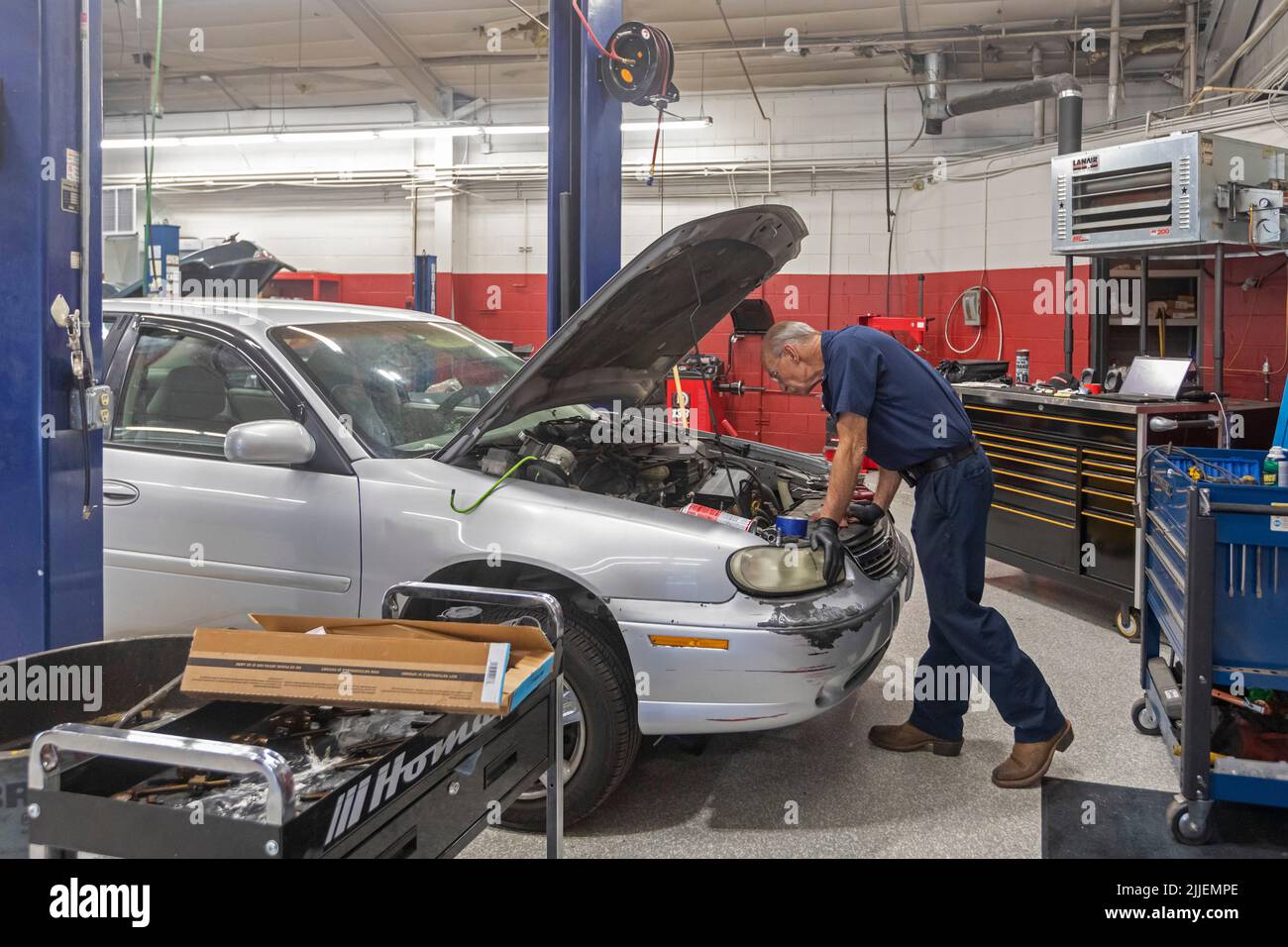 Aurora, Colorado - Russell Bacon fixes a car's oil leak at Hands of the Carpenter. The nonprofit repairs vehicles belonging to single mothers at reduc Stock Photo
