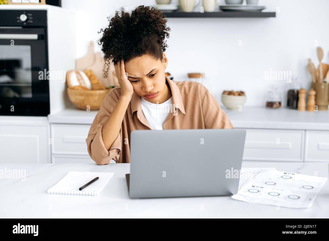 Overworked exhausted young african american woman, freelancer or student, working remotely from home, tired of boring online work, suffering from chronic fatigue, overwork, falls asleep at the desk Stock Photo
