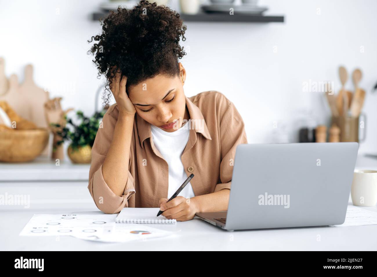 Overworked young african american woman, freelancer or student, working remotely from home, tired of boring online work or study, suffering from chronic fatigue, overwork, falls asleep at the desk Stock Photo