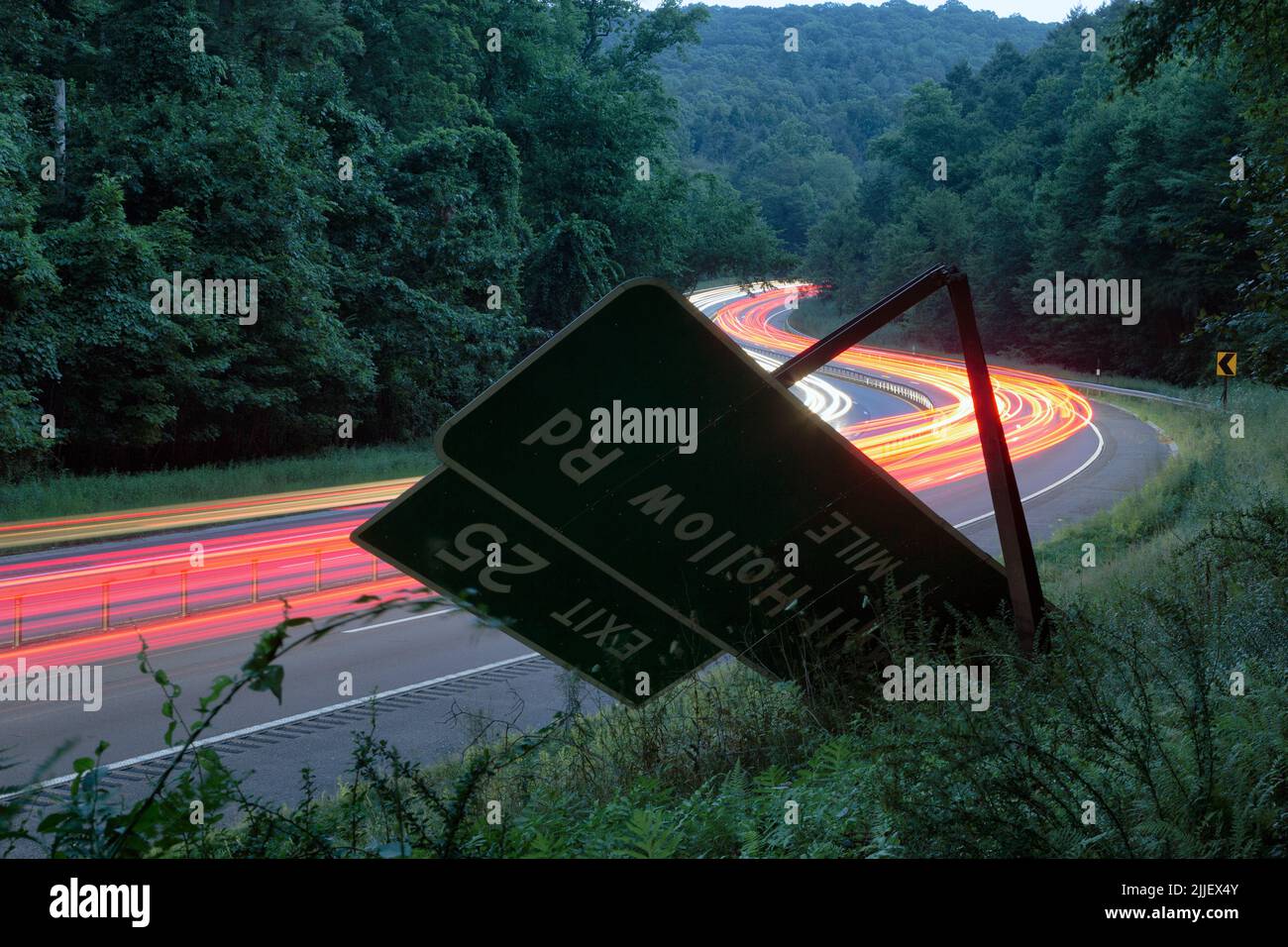 A car crashed through the Peekskill Hollow Road exit sign and proceeded up the embankment and into the woods. All that remains is the damaged sign. Stock Photo