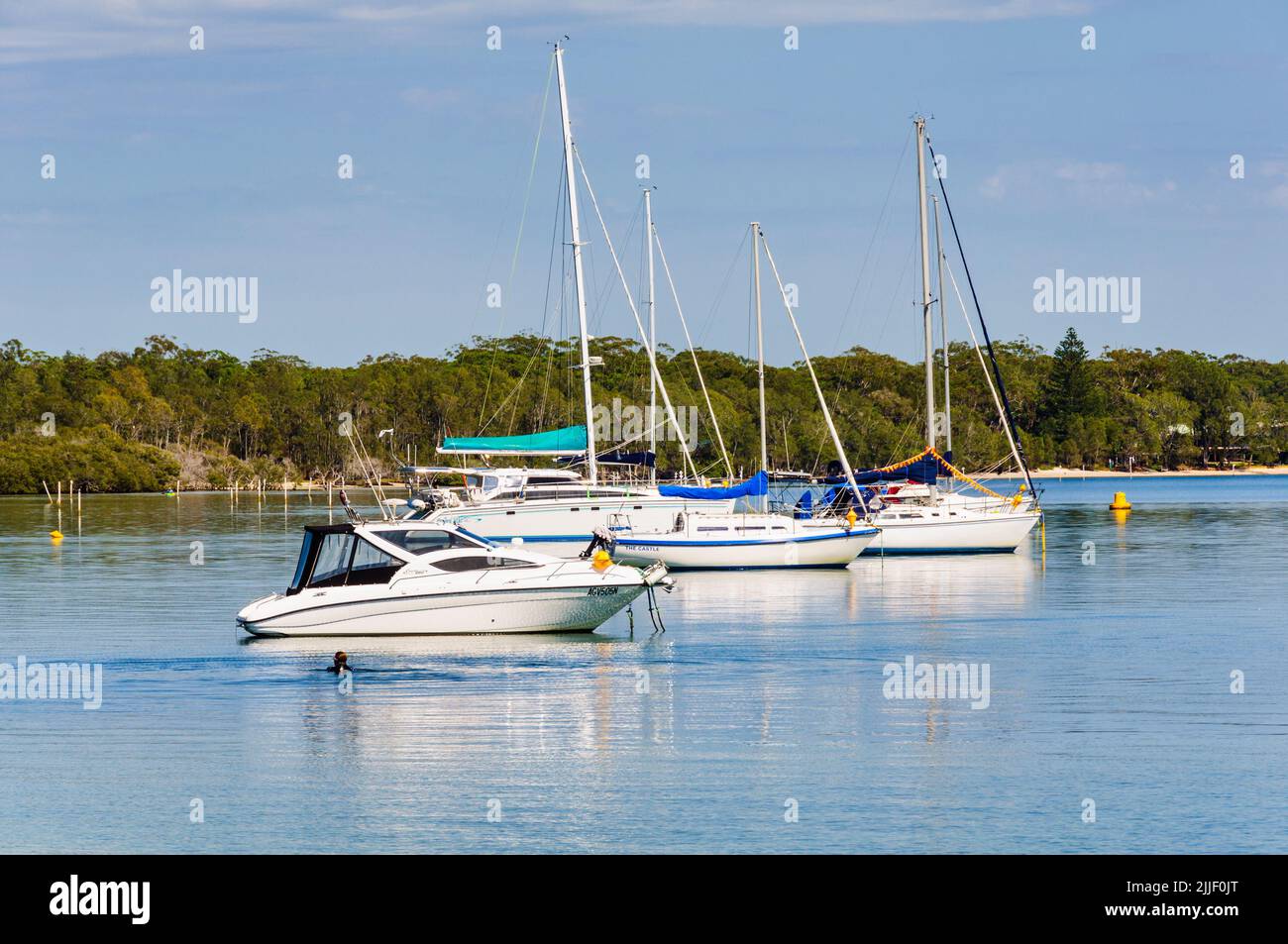 Boats on anchor at Sunset Beach on the peaceful Karuah River - Soldiers Point, NSW, Australia Stock Photo