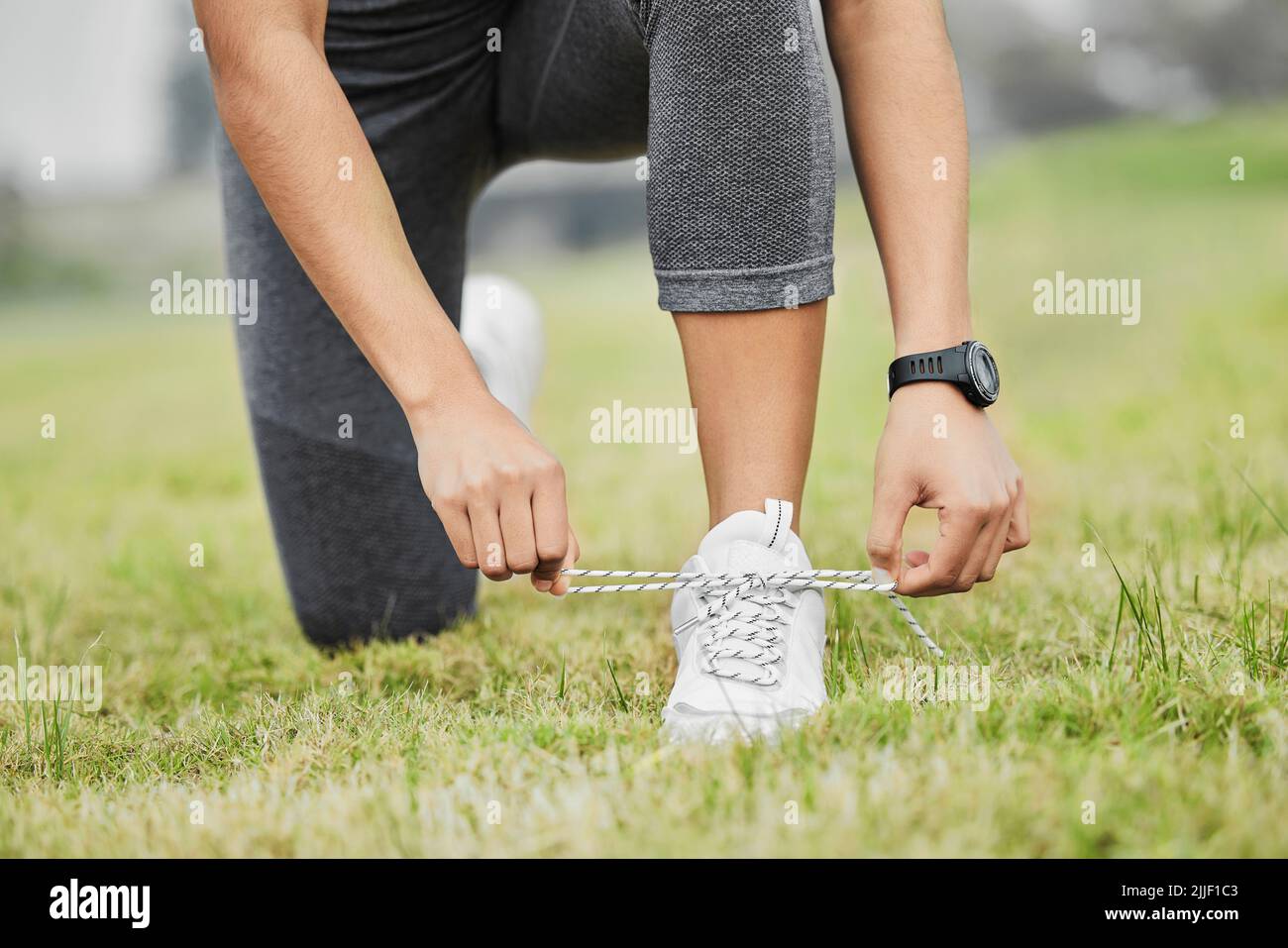 View of Keep it tight. an unrecognizable young female athlete tying her laces ...