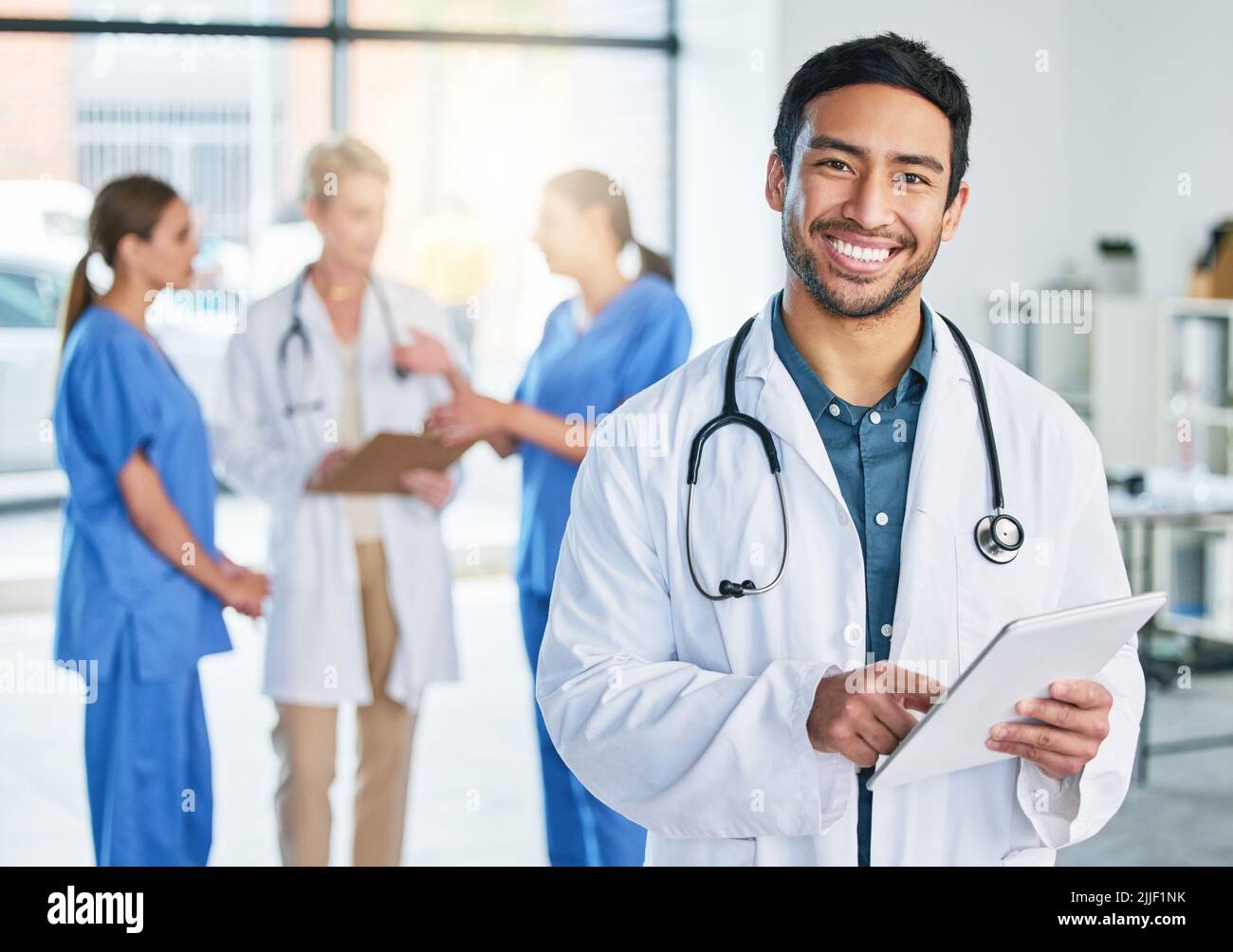 Concentrate all your thoughts upon the work in hand. a young male doctor standing in a hospital. Stock Photo