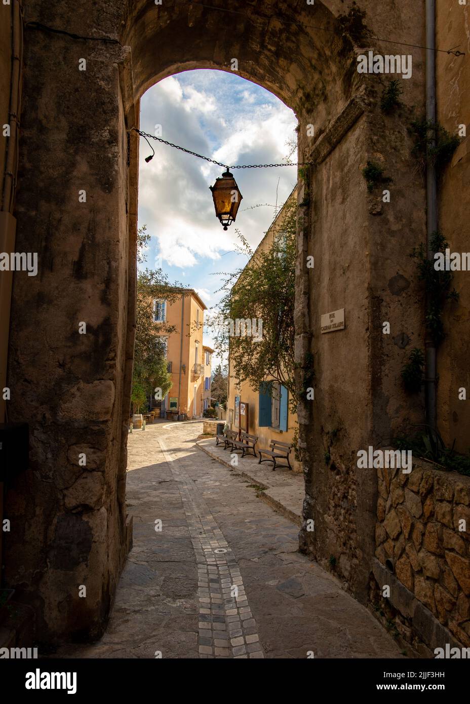 Old street of the village of Gruissan, Southern France, with a door opening to a cobblestone street, taken on a sunny winter late afternoon with no pe Stock Photo