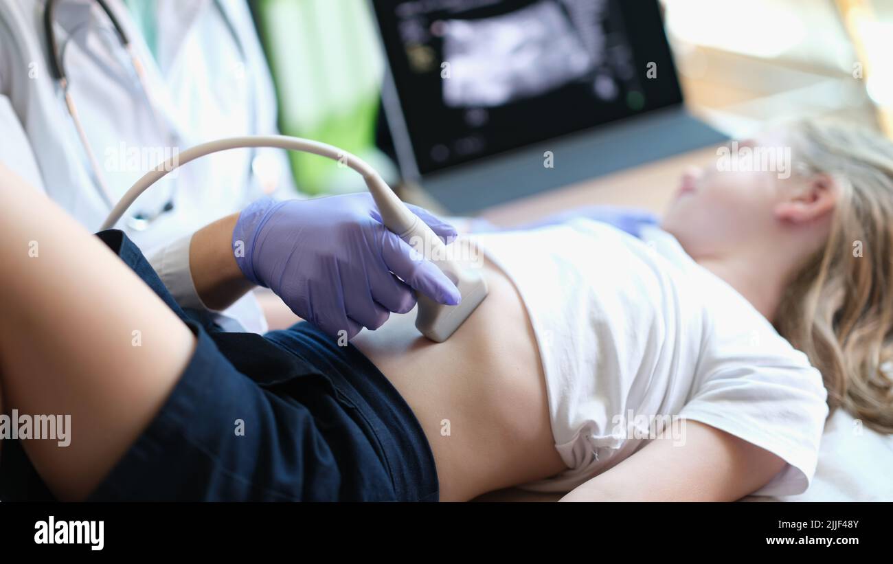 Physician examines with ultrasound of internal organs of child in clinic Stock Photo