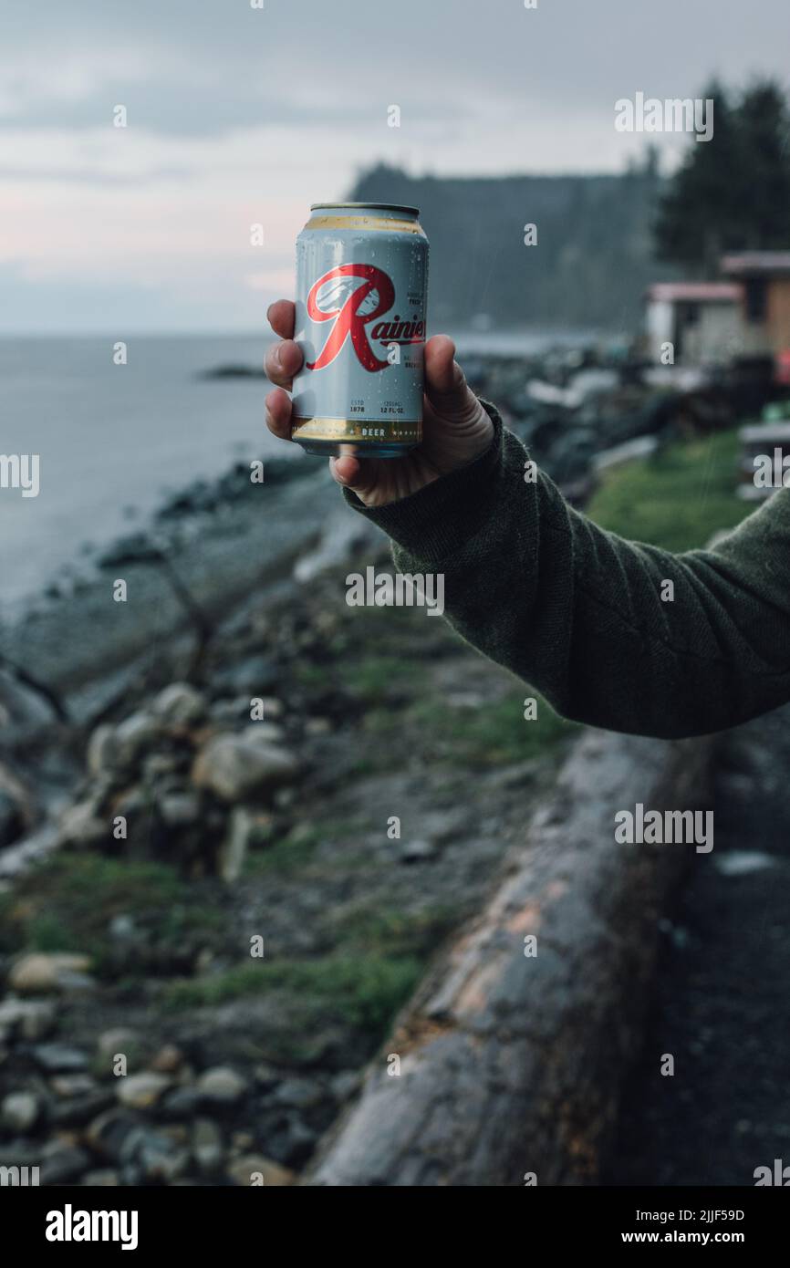hand holding up can of Rainier beer near Port Angeles, WA April 4, 2019