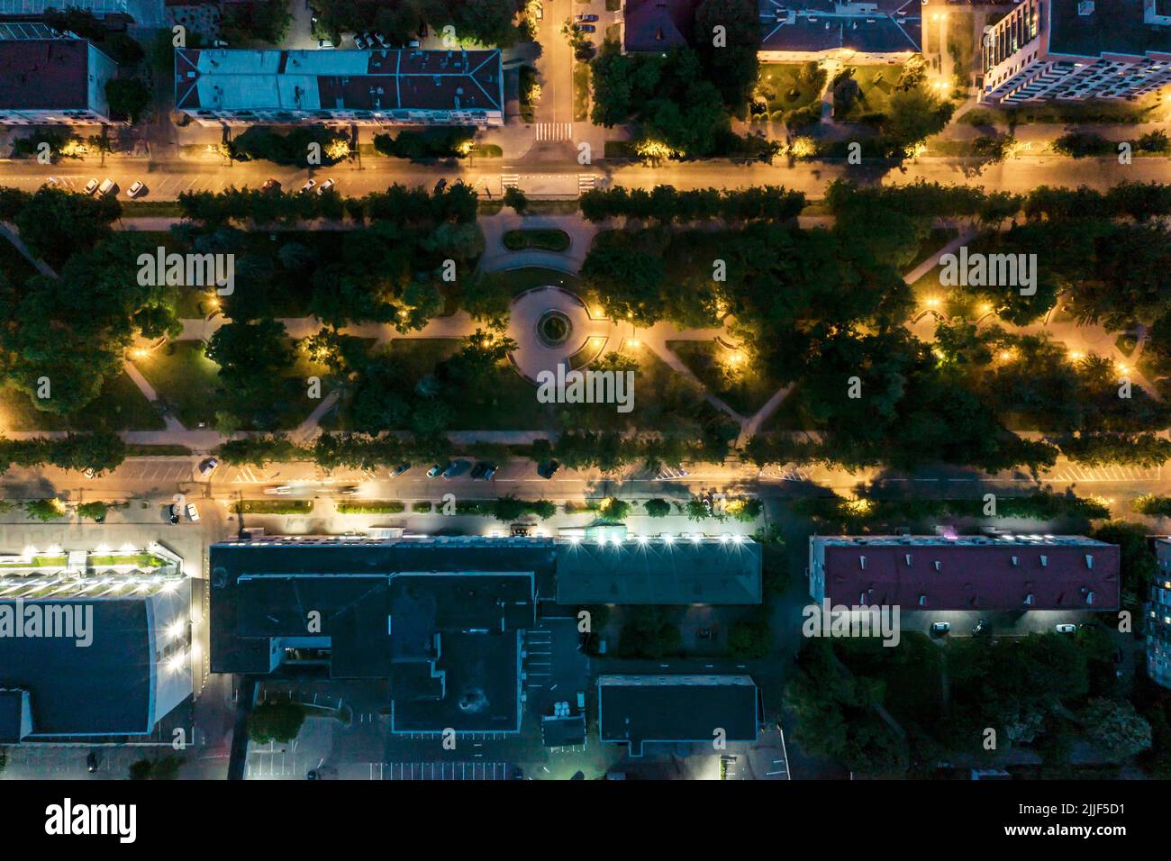 residential area with illuminated boulevard and parking lot with cars. night view. drone photo. Stock Photo