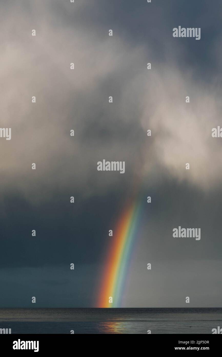 gray clouds with rainbow over the sea ocean Stock Photo