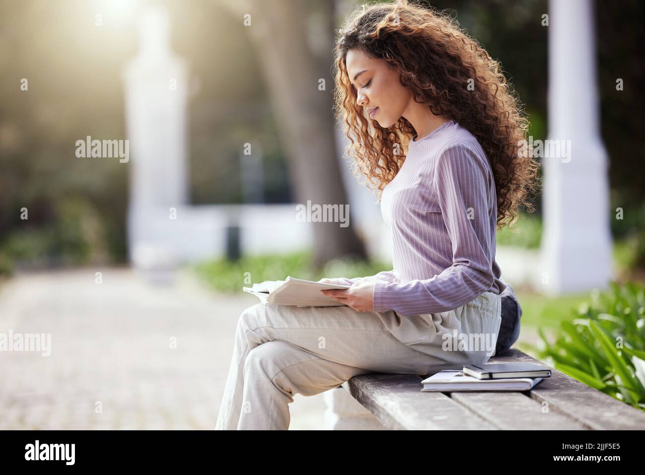 Expand your mind with some reading. a young female student studying in nature. Stock Photo
