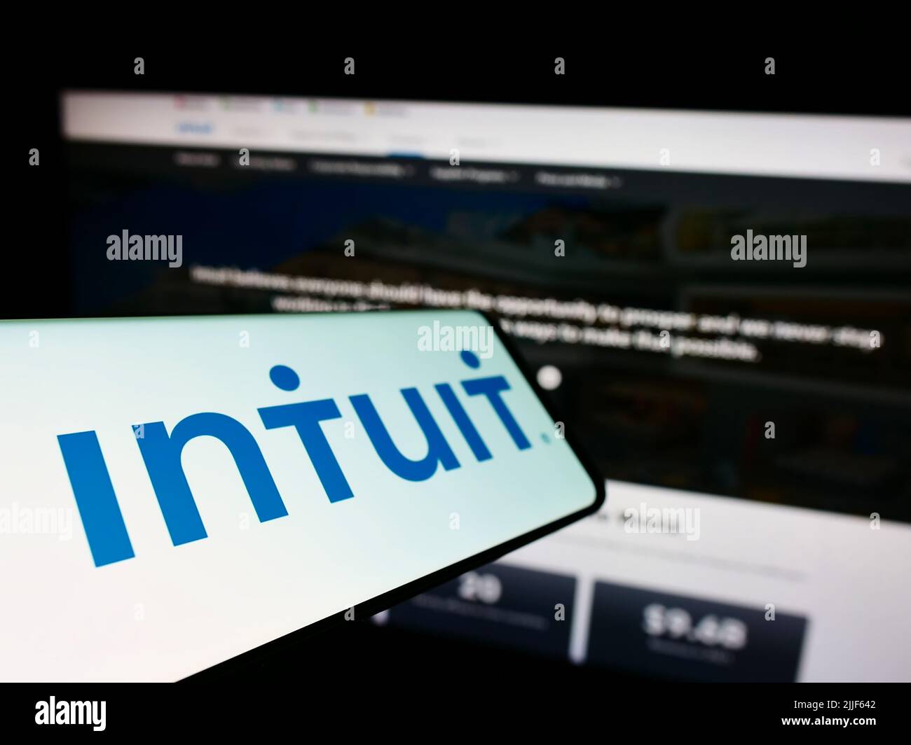 Smartphone with logo of American financial software company Intuit Inc. on screen in front of business website. Focus on left of phone display. Stock Photo