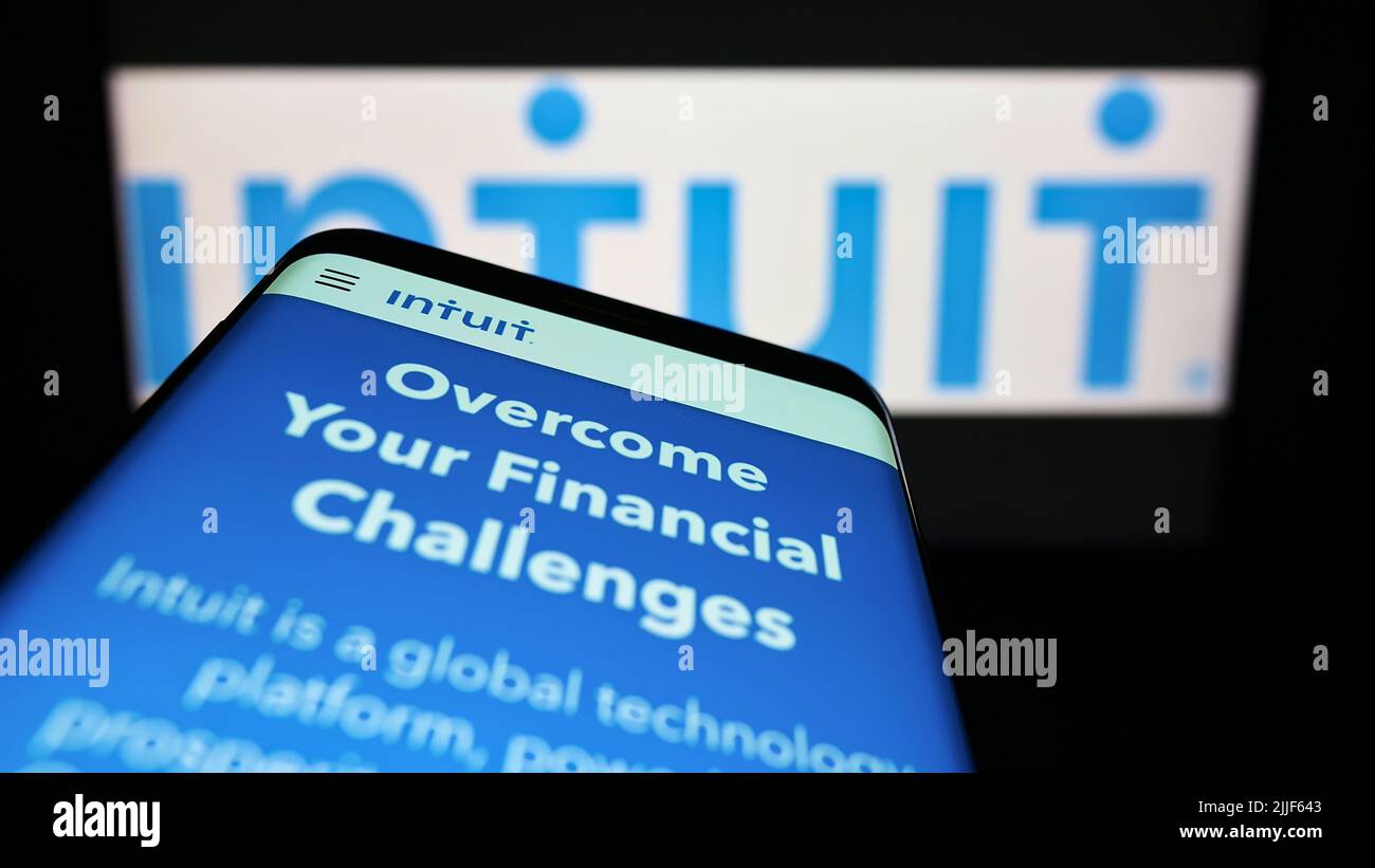 Mobile phone with website of US financial software company Intuit Inc. on screen in front of business logo. Focus on top-left of phone display. Stock Photo