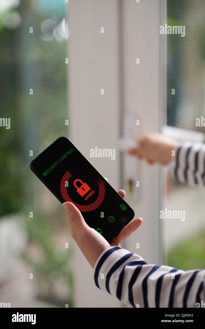 Hands of young woman using security control application on smartphone