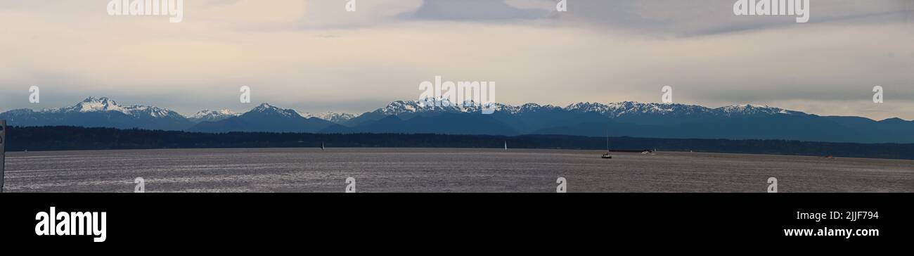 Olympic Mountains from Golden Gardens, Seattle, on a cloudy day. Panorama. Stock Photo