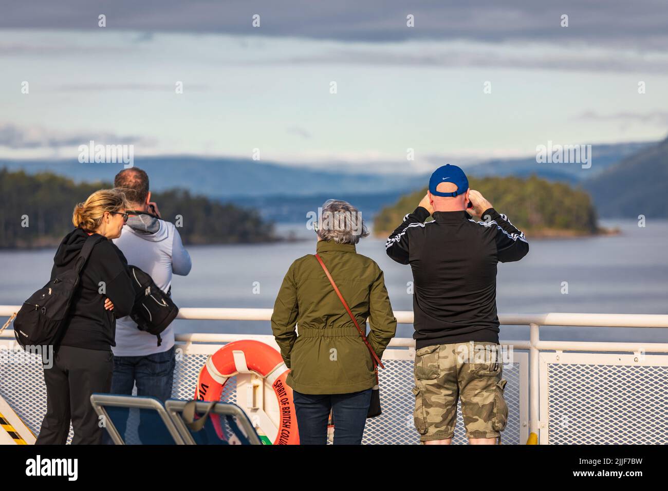 People on a ferry looking into the distance. Passengers on excursion ship or ferry on holiday boat trip in tourism, vacation travel concept. Copy spac Stock Photo