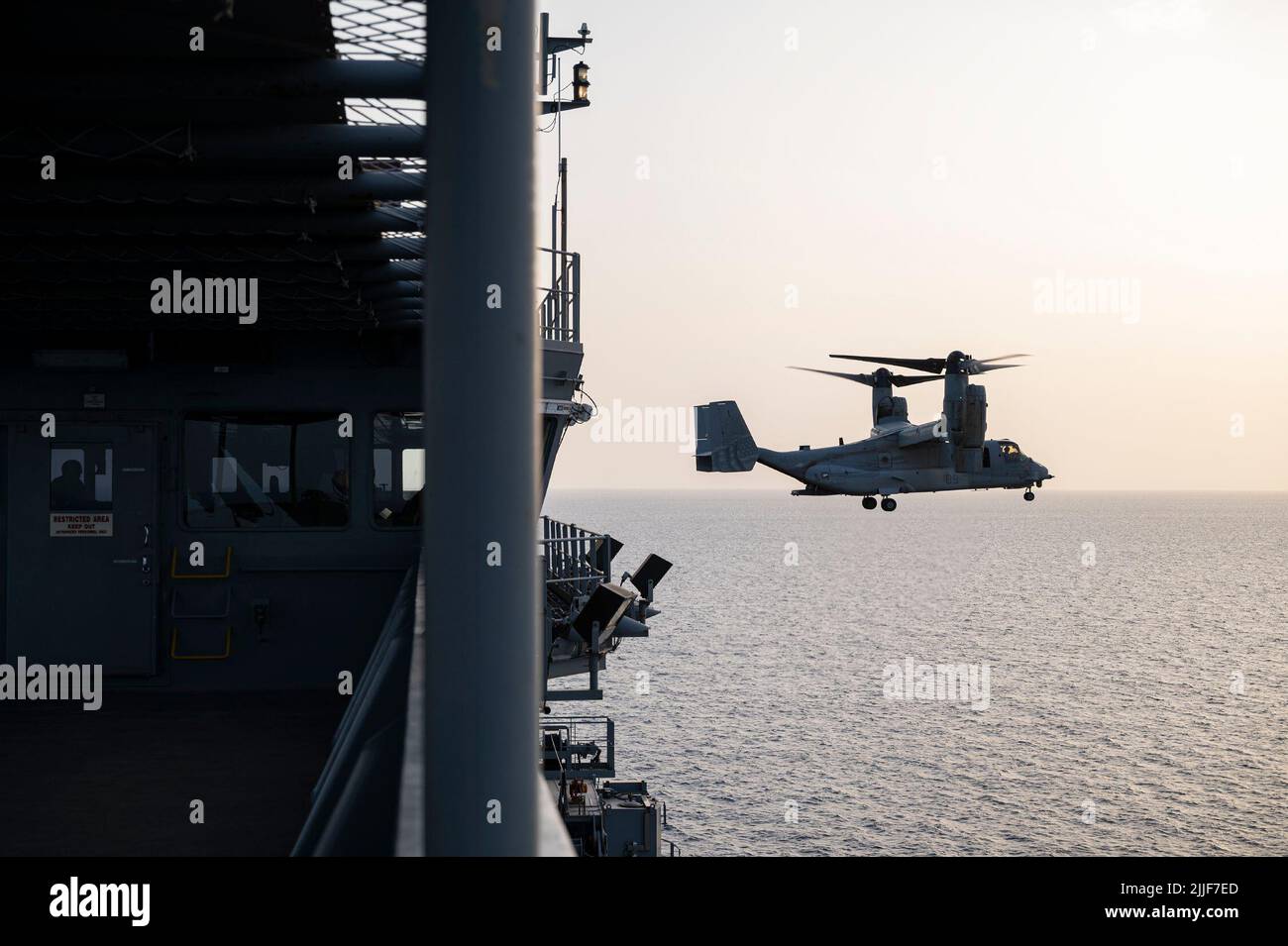 A U.S. Marine Corps MV-22 Osprey assigned to Marine Medium Tiltrotor  Squadron (VMM) 163 flies by USS Hershel 'Woody' Williams (ESB 4) in the Gulf  of Aden, July 13, 2022. Hershel 'Woody' Williams is on a scheduled  deployment in the U.S. Naval Forces Africa area of operations, employed by  U.S. Sixth Fleet to defend U.S., allied and partner interests. (U.S. Air  Force photo by Senior Airman Bryan Guthrie) Stock Photo