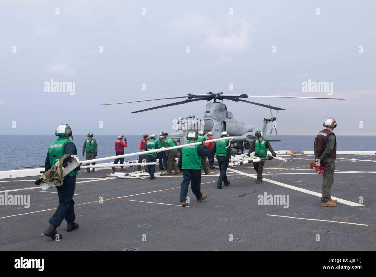 220725-N-XB010-1007 SOUTH CHINA SEA (July 25, 2022) Sailors assigned to the forward-deployed amphibious transport dock ship USS New Orleans’ (LPD 18) and Marines assigned to the 31st Marine Expeditionary Unit (MEU) approach a AH-1Z Cobra helicopter with a blade fold rack on New Orleans’ flight deck. New Orleans, part of the Tripoli Amphibious Ready Group, along with the 31st MEU, is operating in the U.S. 7th Fleet area of responsibility to enhance interoperability with allies and partners and serve as a ready response force to defend peace and stability in the Indo-Pacific region. (U.S. Navy p Stock Photo