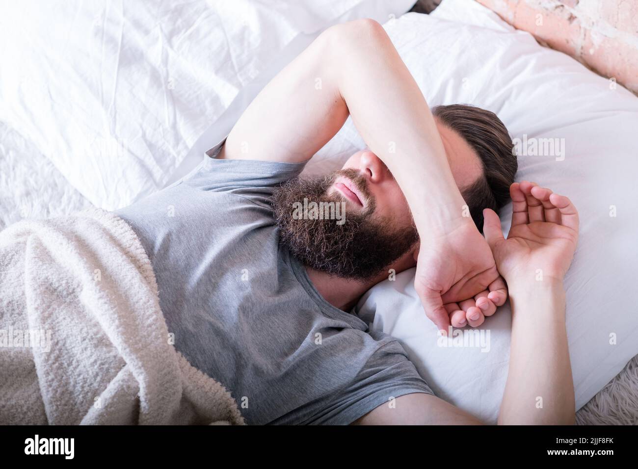 monday morning laziness man bed covering eyes Stock Photo