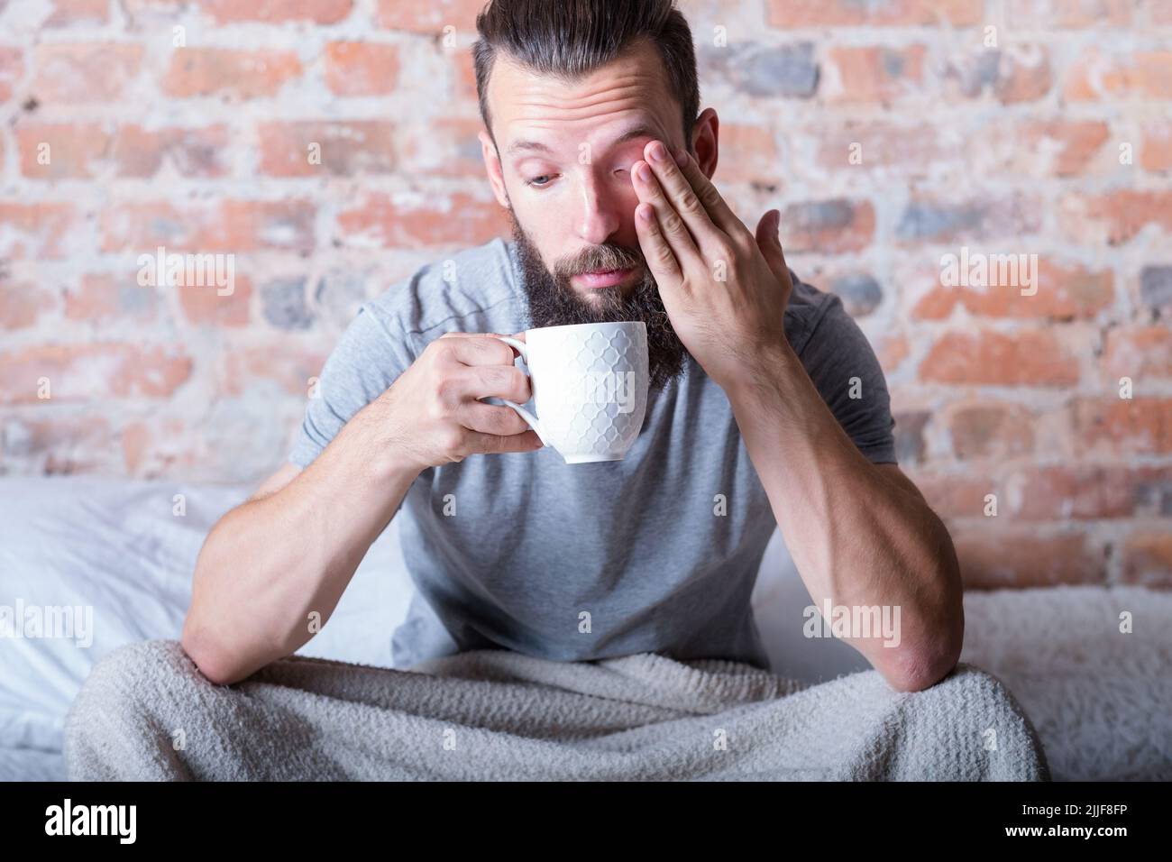 monday morning drowsiness man bed cup distracted Stock Photo