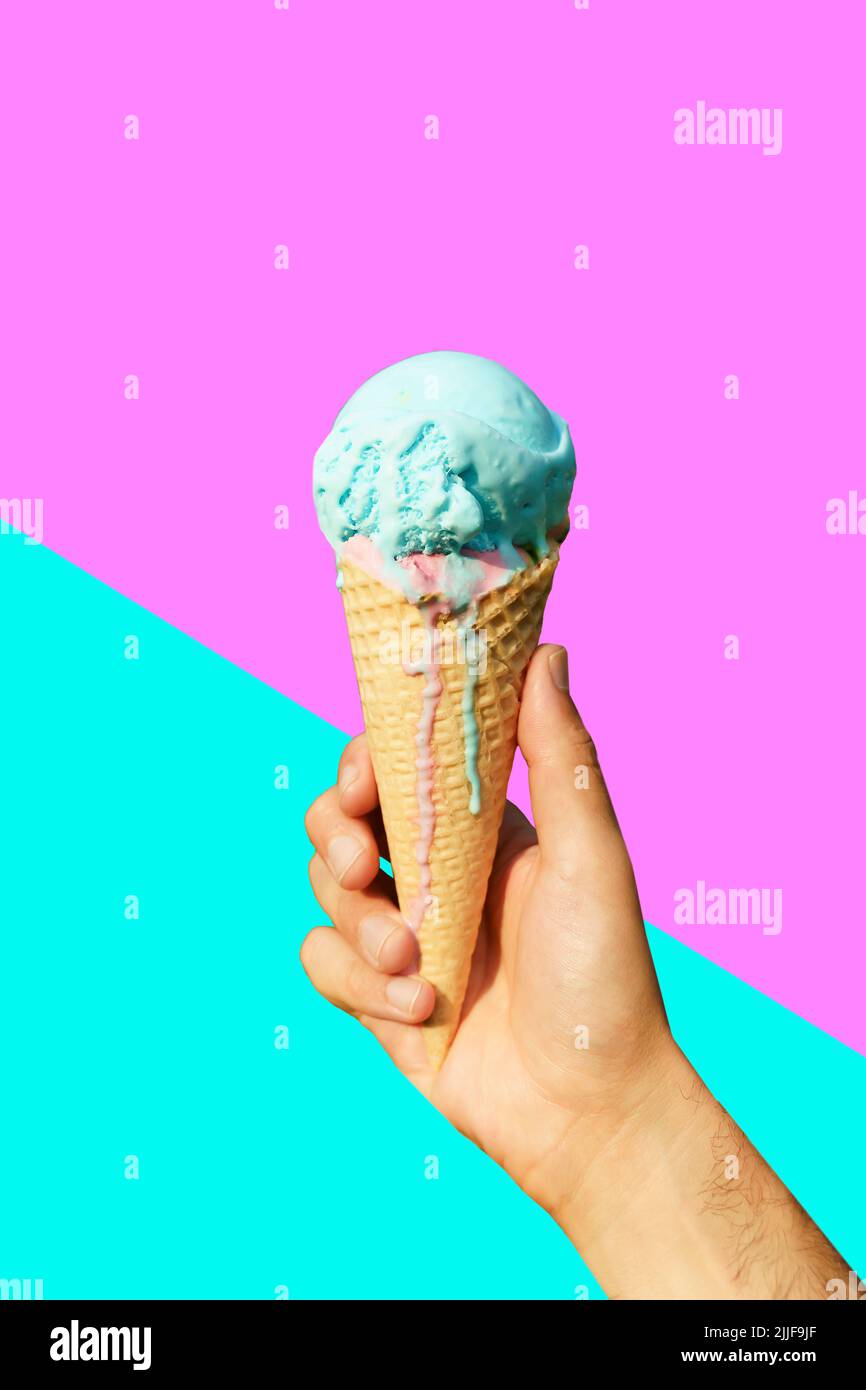 Ice cream cone in hand on minimal color background isolated. Summer