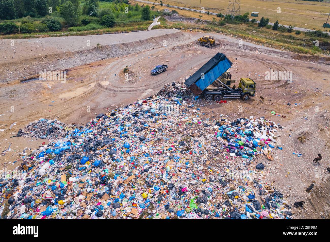 Large truck reloading plastic waste over beach landfill. Climate change and plastic pollution concept. High quality photo Stock Photo